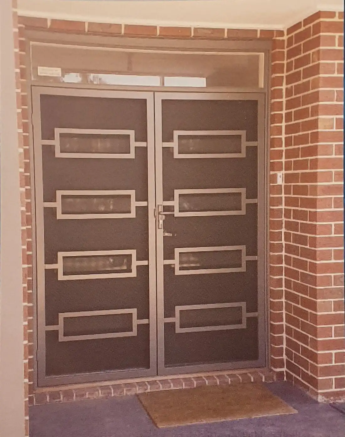 Bronze security doors brick entrance installation by SupaScreens.