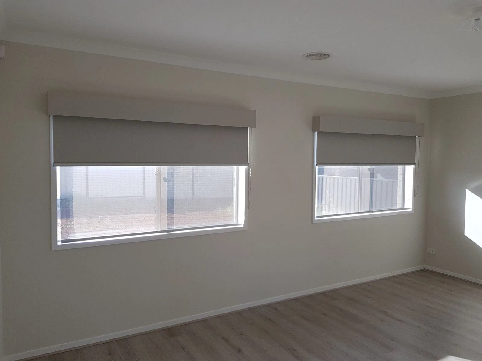 Grey roller blinds bedroom windows installation by SupaScreens.