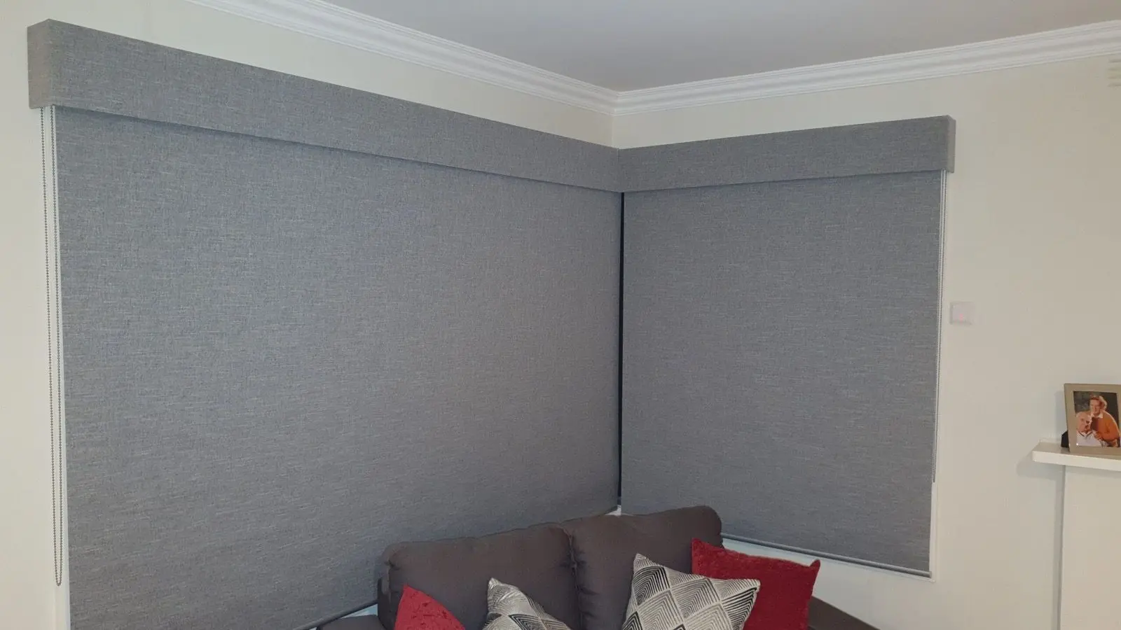 Grey roller blinds corner lounge installation by SupaScreens.