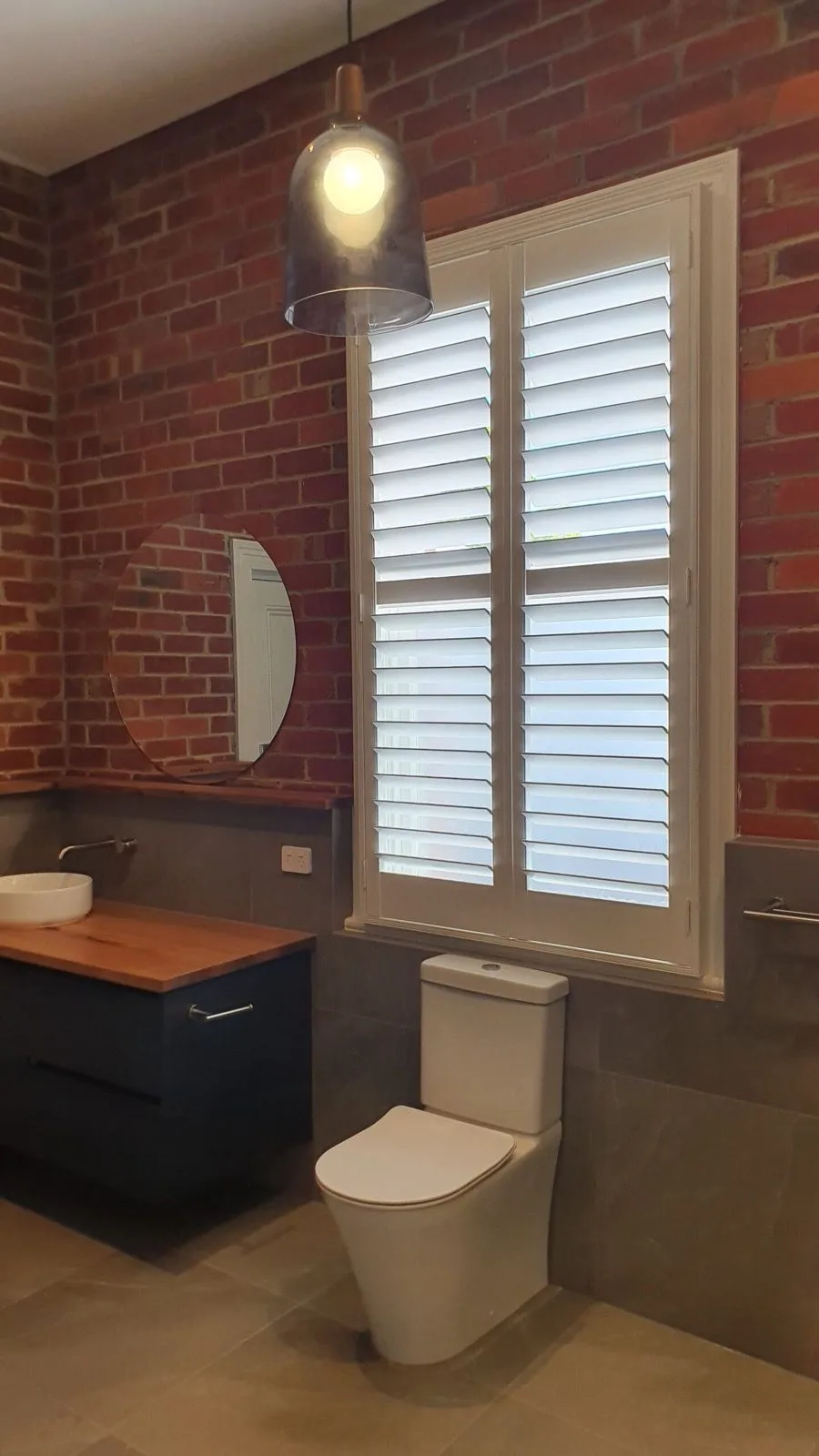 White plantation shutters brick bathroom installation by SupaScreens.